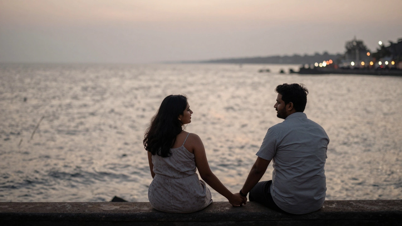 A couple holding hands on Marine Drive in Mumbai as the sun sets over the ocean.
